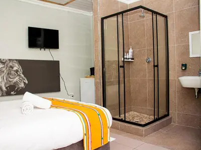a bathroom with a shower and a bed and a sink at Maseyi On 8 bnb in Cape Town