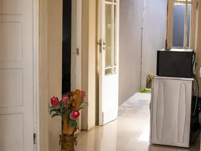 a vase of flowers sitting on the floor in a hallway at Maseyi On 8 bnb in Cape Town
