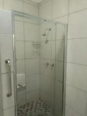 a bathroom with a shower with a glass door at LRN Brackenfell Homestay in Cape Town