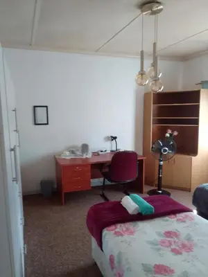 a bedroom with a desk and a bed and a chair at LRN Brackenfell Homestay in Cape Town
