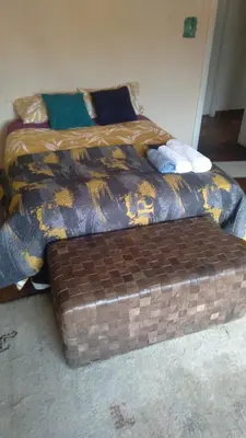 a bed in a room with a trunk next to it at LRN Brackenfell Homestay in Cape Town