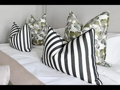 a bed with four pillows on top of it at The Village Cottage in Franschhoek