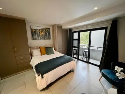 a bedroom with a large bed and a balcony at Modern Apartment in Stellenbosch in Stellenbosch
