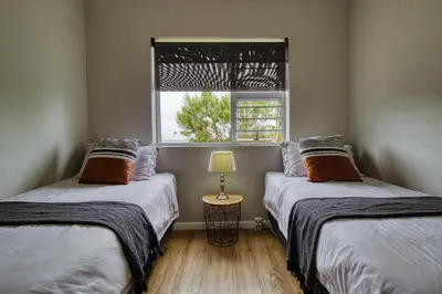two twin beds in a room with a window at Magnificent Villa Load-Shedding Free! in Cape Town