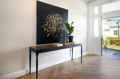 a table in a room with a painting on the wall at Middedorp Manor in Stellenbosch