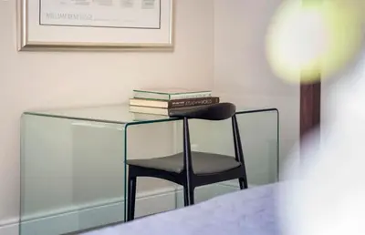 a glass table with a chair and books on it at Middedorp Manor in Stellenbosch