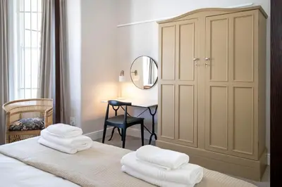 a bedroom with a bed with white towels on it at Middedorp Manor in Stellenbosch