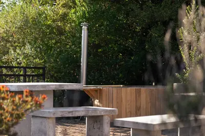 a couple of benches in front of a wooden fence at Avemore Olive Apartment - full Backup power in Stellenbosch