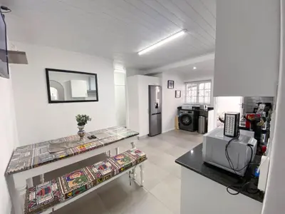 a living room with a counter and a refrigerator at Modern 8 Sleeper home in trendy Observatory in Cape Town