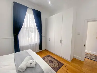 a bedroom with a bed and a large window at Modern 8 Sleeper home in trendy Observatory in Cape Town