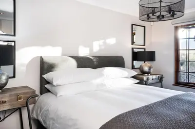 a bedroom with a white bed with white pillows at Avemore Orchard Apartment - with full Backup power in Stellenbosch