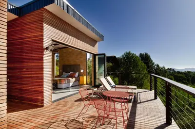 a deck with chairs and a table and a bed at Tulbagh Mountain Bungalow in Wolseley