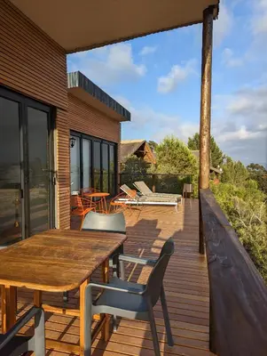 a wooden deck with a wooden table and chairs at Tulbagh Mountain Bungalow in Wolseley
