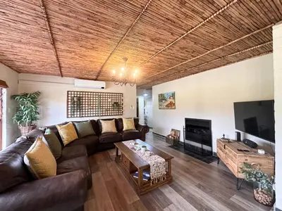 a living room with a couch and a tv at Cottage K'Gari in Franschhoek