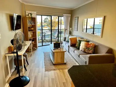 a living room with a couch and a table at Beachside Bliss Strand in Strand
