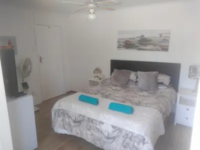a bedroom with a bed with blue blocks on it at Fisherhaven Guest House in Hermanus