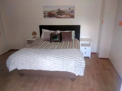 a bedroom with a large bed with white sheets and pillows at Fisherhaven Guest House in Hermanus