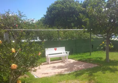 a white bench with a heart on it in a yard at Fisherhaven Guest House in Hermanus