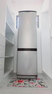 a white refrigerator in a kitchen with a rug at Cosy Nest - Uncapped Wi-fi & Self Check-in in Cape Town