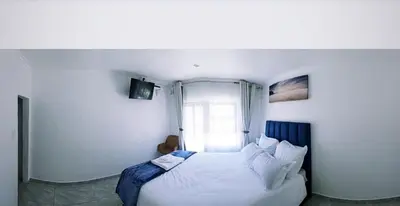 a bedroom with a white bed and a window at Blue Nile Guest in Cape Town