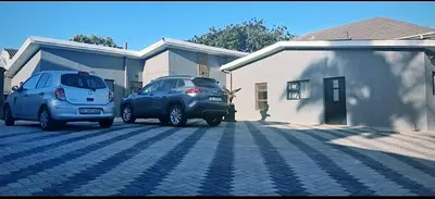 two cars parked in a parking lot next to a house at Blue Nile Guest in Cape Town