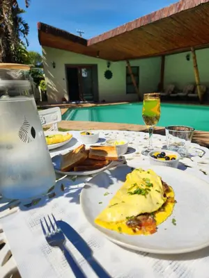 a table with a plate of food and a glass of wine at Durbanville Pool House in Durbanville