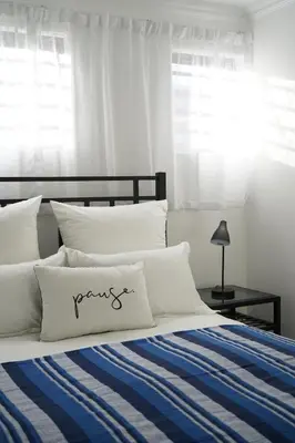 a bedroom with a bed with a blue and white blanket at Nature's Rest in Cape Town