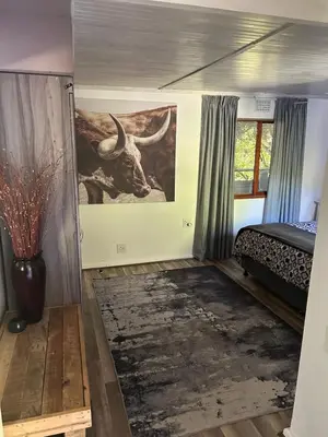 a bedroom with a painting of a bull on the wall at Garden View Inn in Cape Town