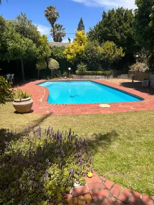a large swimming pool in a yard with a yard at Garden View Inn in Cape Town