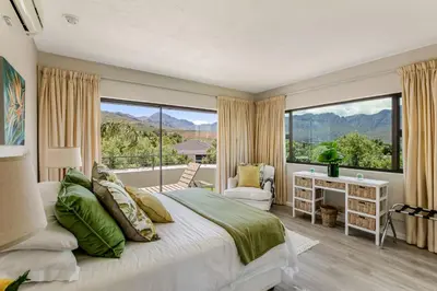 a bedroom with a bed and a large window at Erinvale Luxury Villa in Cape Town