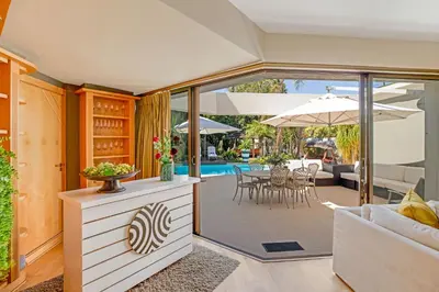 a living room with a patio with an umbrella at Erinvale Luxury Villa in Cape Town