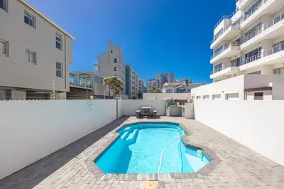 a swimming pool on the side of a building at Blouberg Pearl in Cape Town