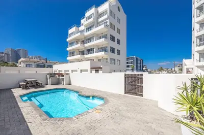 a swimming pool on the roof of a building at Blouberg Pearl in Cape Town