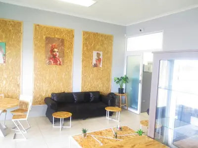 a living room with a black couch and a table at lodgeon91 in Cape Town