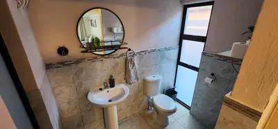 a bathroom with a sink and a mirror and a toilet at Cozy Batchelor Labiance in Cape Town