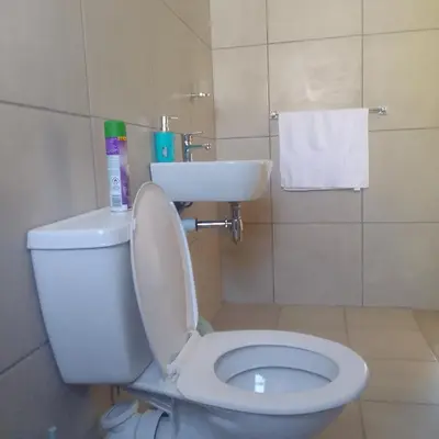 a bathroom with a white toilet and a sink at Naliya Guest house in Cape Town
