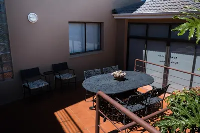 a patio with a table and chairs on a balcony at Grandview Guesthouse in Cape Town