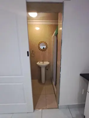 a bathroom with a sink and a mirror at Olivia's guest house in Cape Town