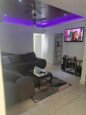 a living room with a couch and a tv at Olivia's guest house in Cape Town