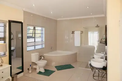 a bathroom with a tub and a toilet and a sink at Lovely and Peaceful 3 bedroom house in Cape Town