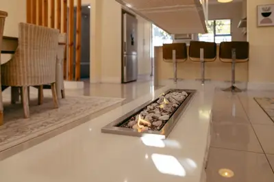 a fireplace in the middle of a living room at Lovely and Peaceful 3 bedroom house in Cape Town