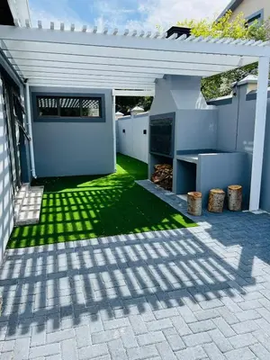 a backyard with a patio with green grass at Lovely and Peaceful 3 bedroom house in Cape Town