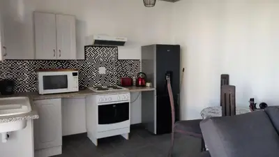a kitchen with a stove and a microwave at Whalers Retreat in Bettyʼs Bay