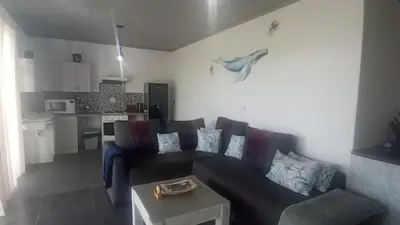 a living room with a couch and a table at Whalers Retreat in Bettyʼs Bay