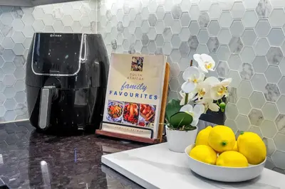 a counter with a bowl of lemons and a book and flowers at Rancho Relaxo in Bloubergstrand
