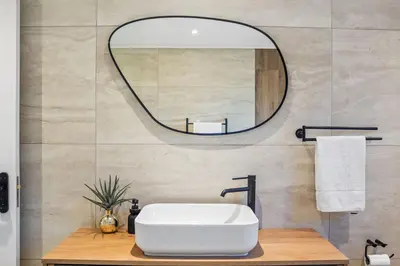 a bathroom with a white sink and a mirror at Rancho Relaxo in Bloubergstrand