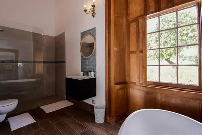 a bathroom with a toilet and a sink and a mirror at Heins Manor House in Stellenbosch