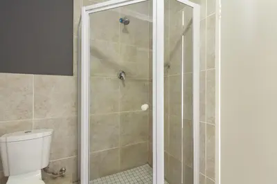 a bathroom with a shower with a toilet at Waterstone East C103 by Host Agents in Cape Town