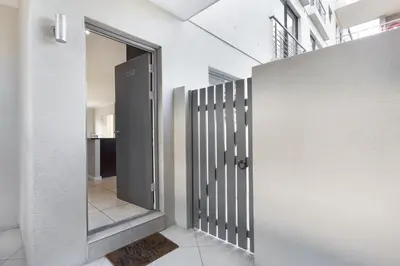 a pivot door in a hallway of a house at Waterstone East C103 by Host Agents in Cape Town