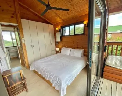 a bedroom with a bed and a ceiling fan at Milkwood Cabin Getaway in Lake Marina